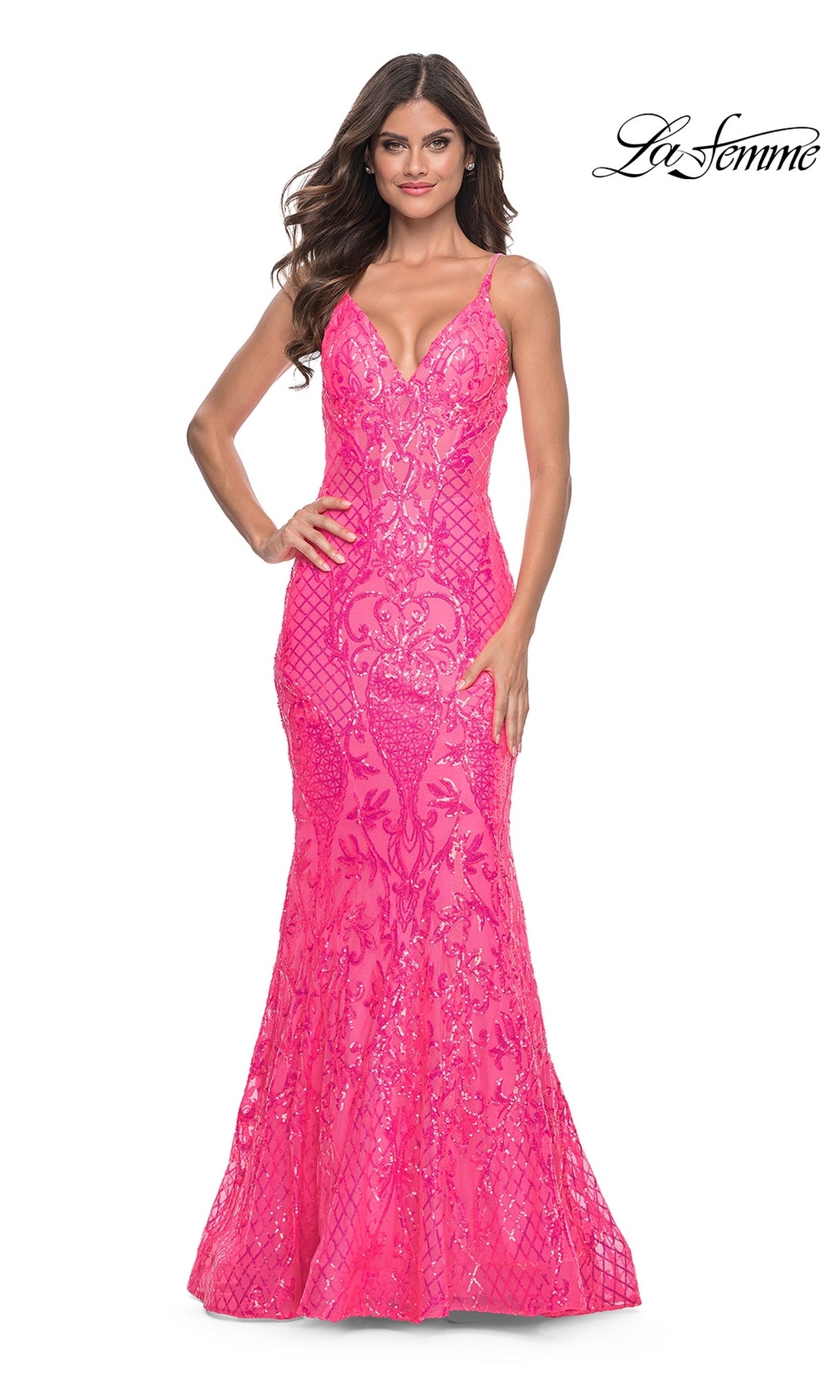 Woman wearing the La Femme Long Sequin Mermaid Prom Dress 32337—fitted, bright pink with thin straps and sequin detailing—standing against a white background.
